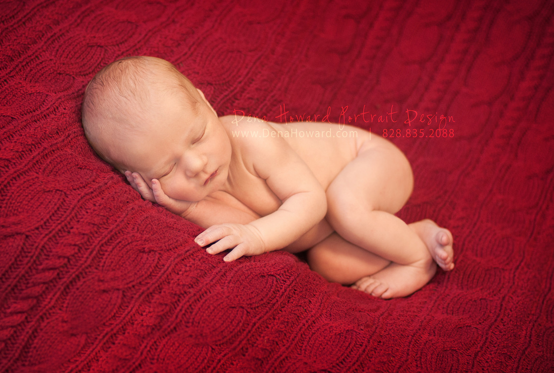 Newborn baby boy on red cable knit throw
